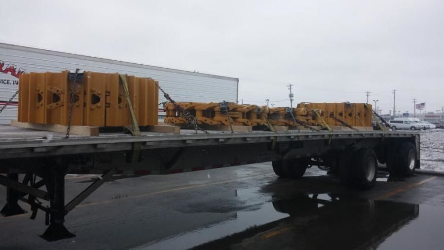 bulldozer tracks strapped on a flatbed trailer