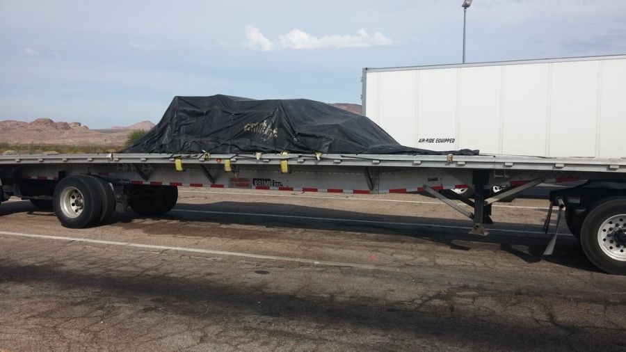 slate roofing material tarped and strapped on a flatbed trailer