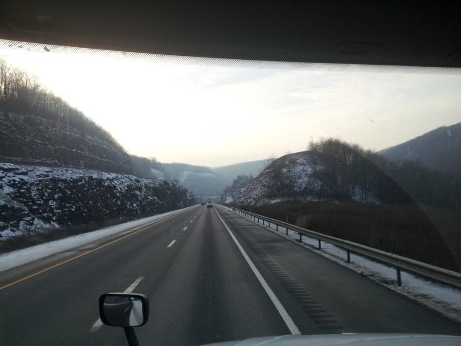 View from the driver's seat of a tractor trailer going through a mountain pass.