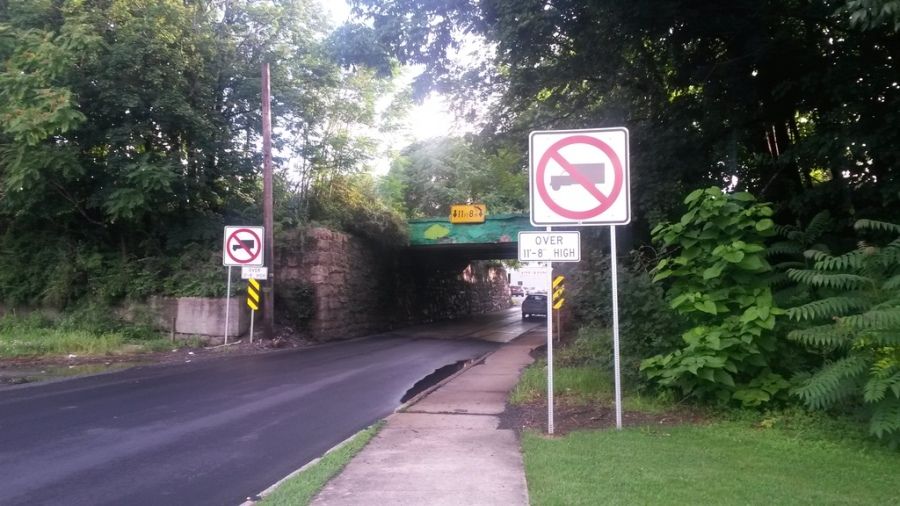 no trucks sign before a small low bridge