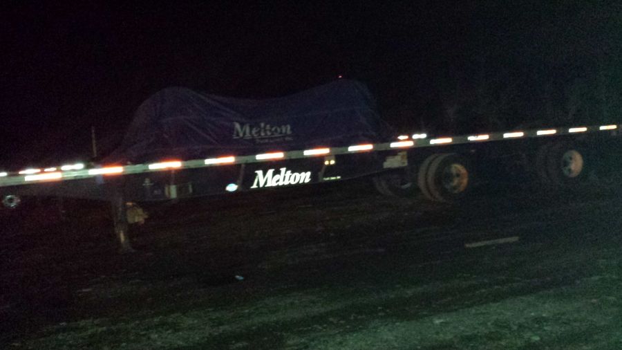 loaded strapped and tarped Melton flatbed trailer at night