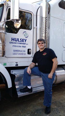 truck driver standing in front of a Hulsey Grease Company tractor trailer