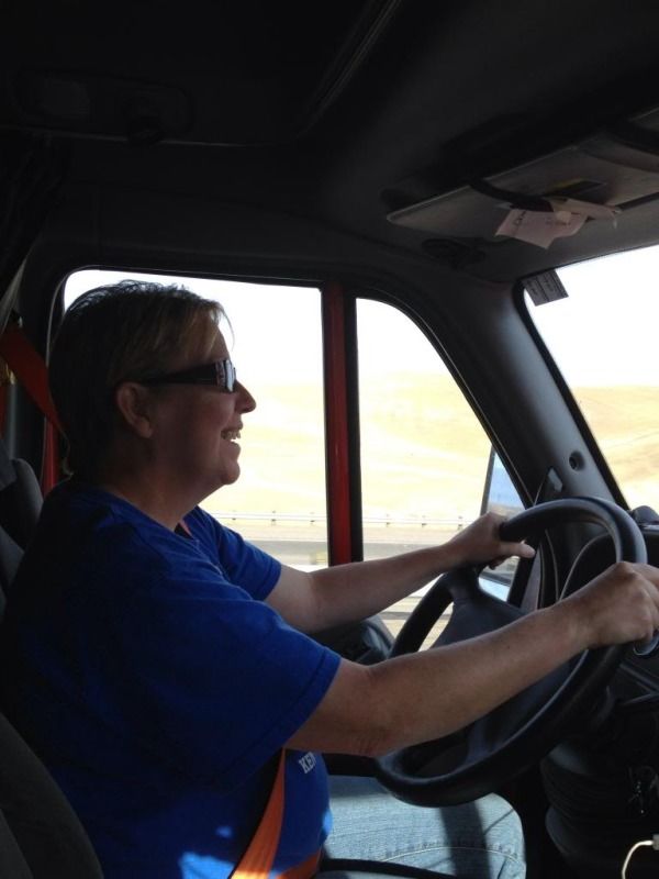 woman truck driver in the cab behind the wheel