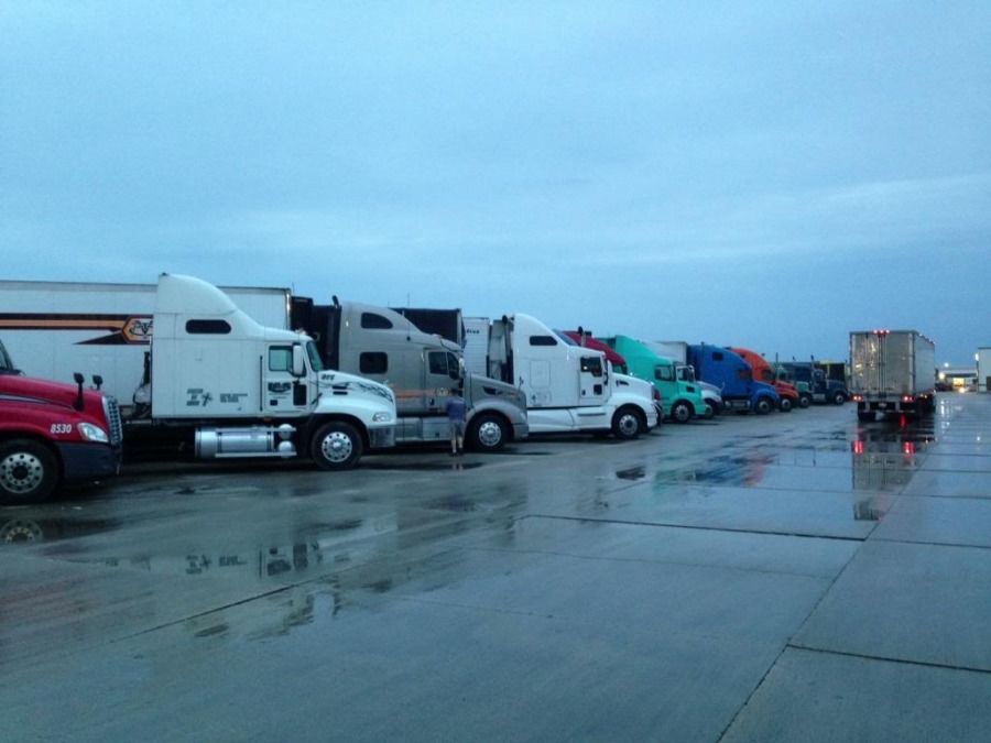 line of trucks parked at truck-stop on a rainy day
