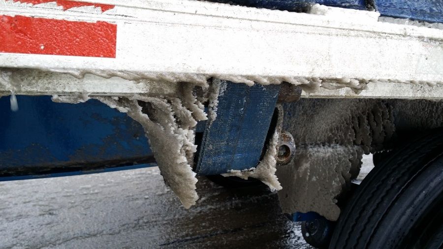 Blue Melton Kenworth flatbed tarped and strapped trailer iced over from Pennsylvania ice storm