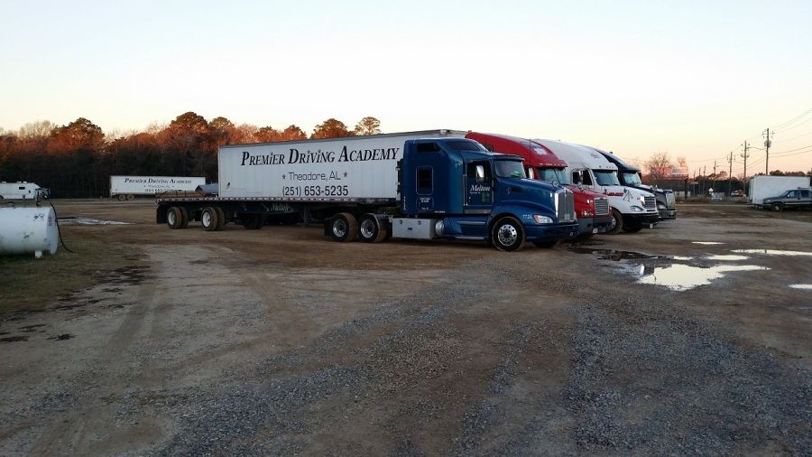 blue Melton flatbed truck parked at Premier Driving Academy