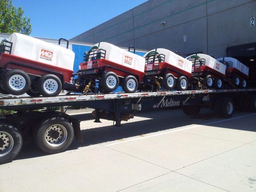 Melton flatbed trailer loaded delivering small portable spray tank trailers