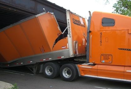 trucking accident crash orange Schneider truck gets trailer stuck under low bridge