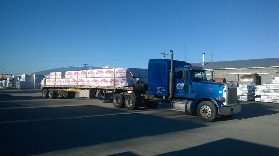 flatbed trailer loaded with lumber and building materials and tarped