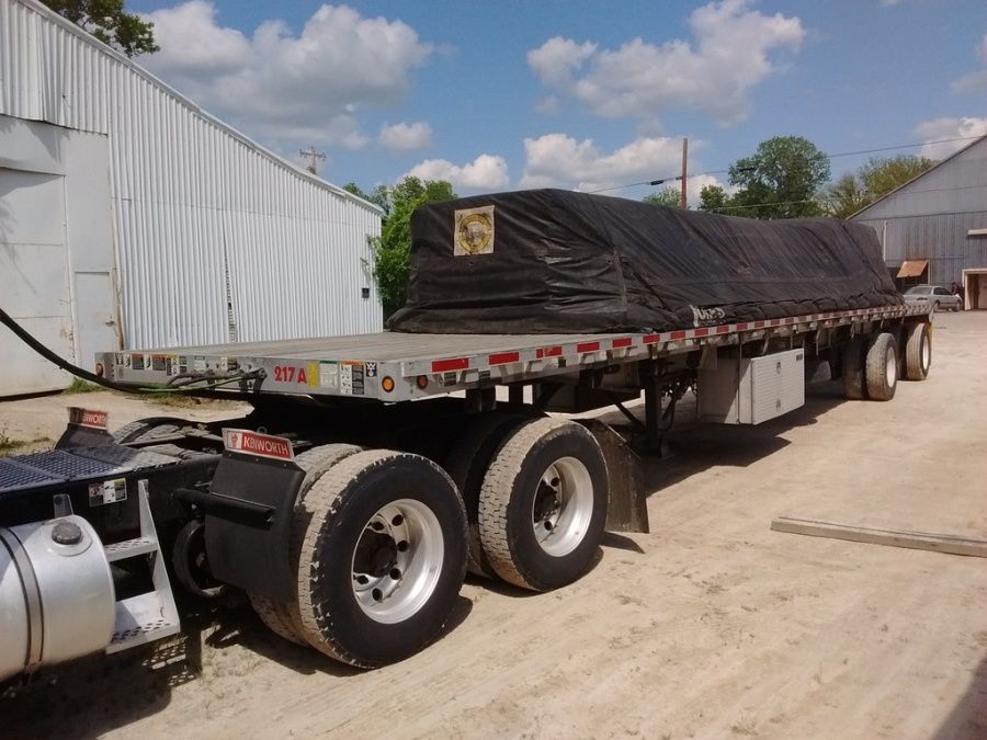 steel grates loaded strapped and tarped on flatbed trailer