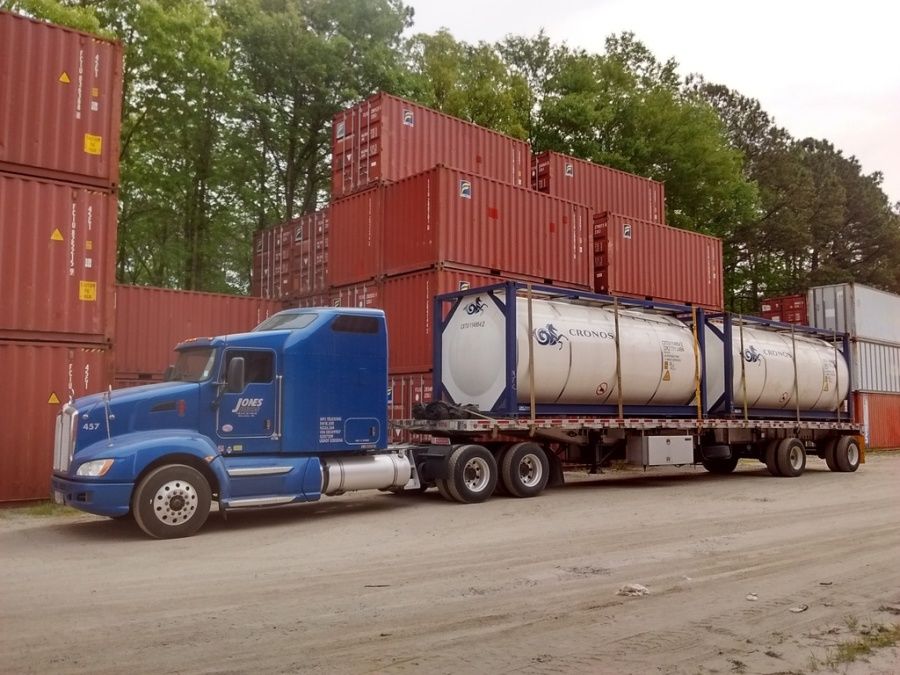 blue Jones flatbed trailer loaded with bulk liquid tank containers