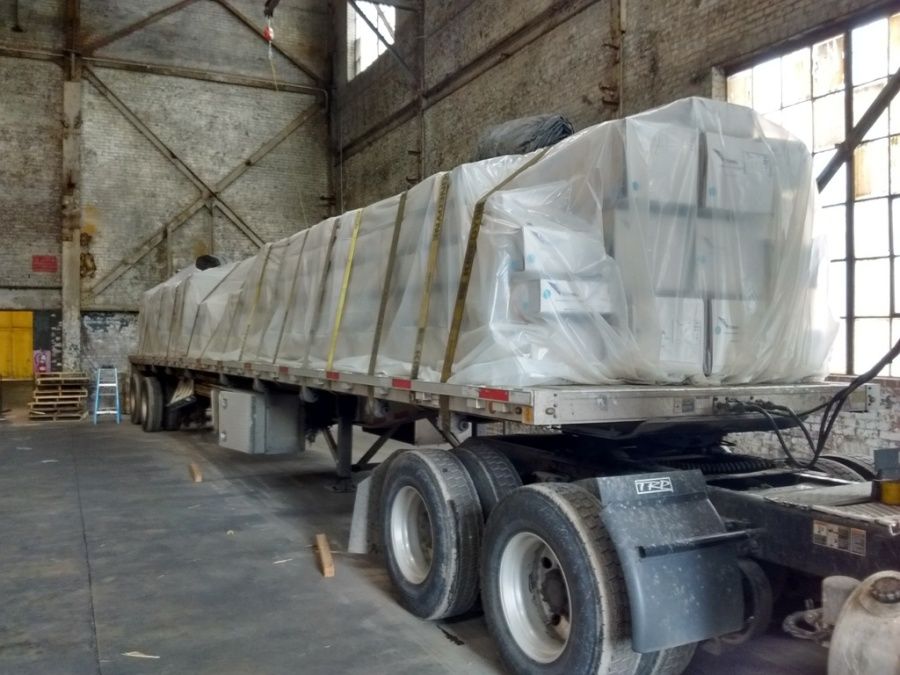 boxes of aluminum extrusions loaded and strapped on flatbed inside warehouse