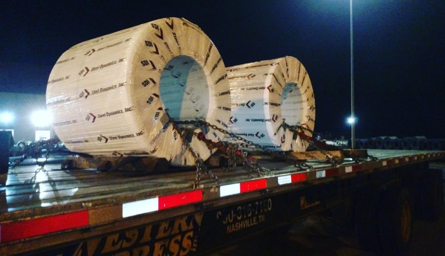 metal coils loaded on flatbed trailer with eyes horizontal at night