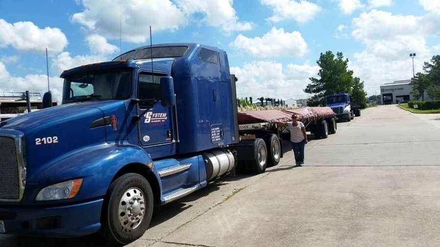 lady truck driver with flatbed trailer loaded with aluminum