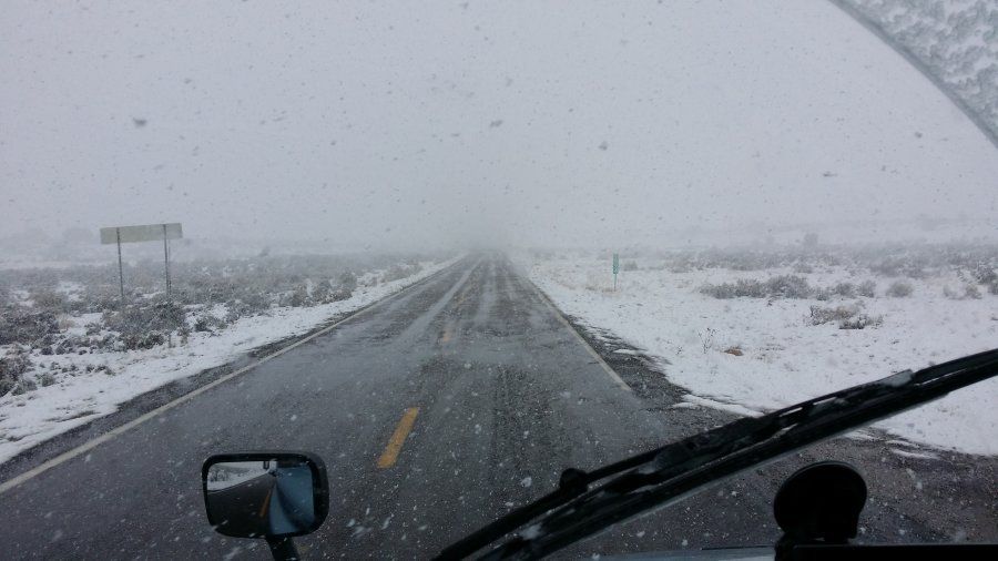 trucker driving in a snow whiteout in the mountains