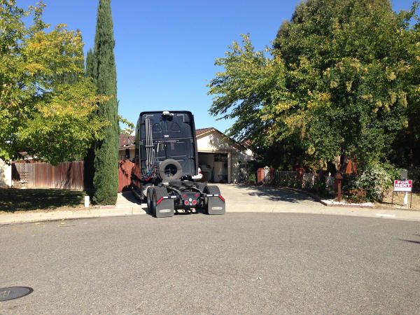 truck driver parking his truck in his driveway at home
