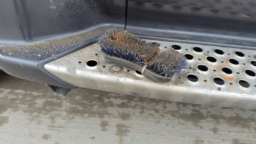 brush attached to truck doorstep for wiping feet to keep cab clean
