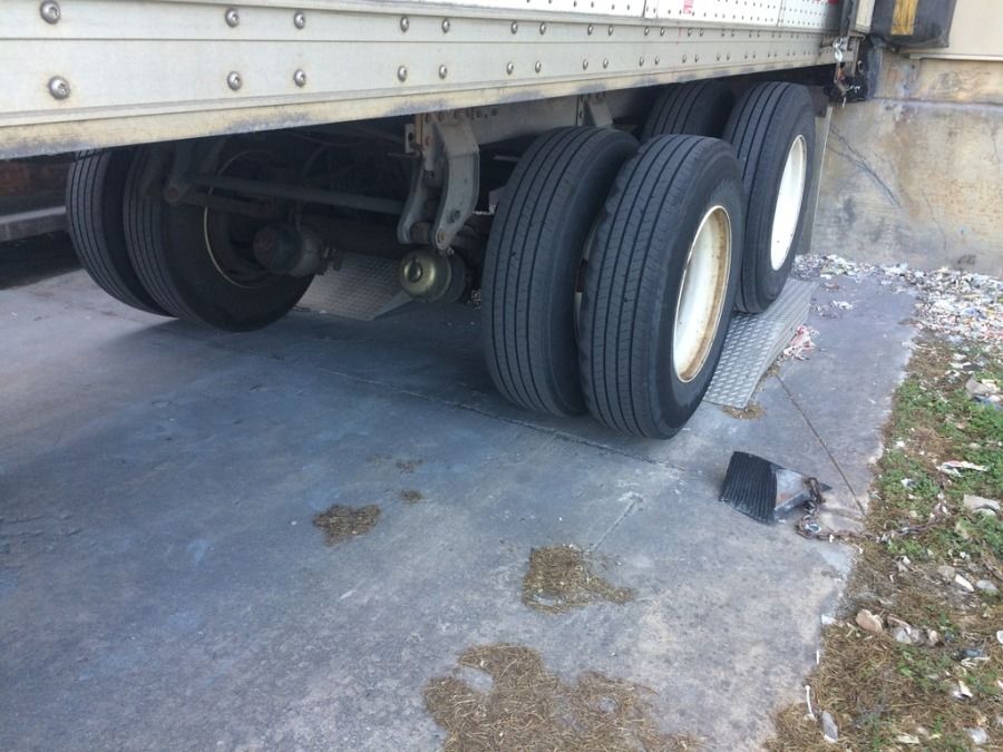 semi-truck trailer parked on ramps with wheel chocks