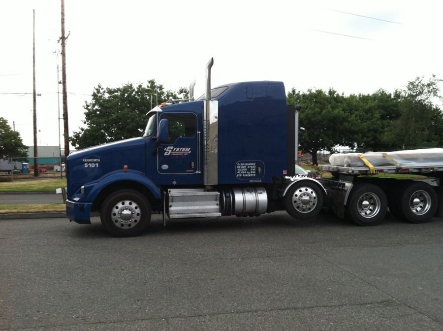 blue Systems Transport Kenworth truck with flatbed trailer coupled to it
