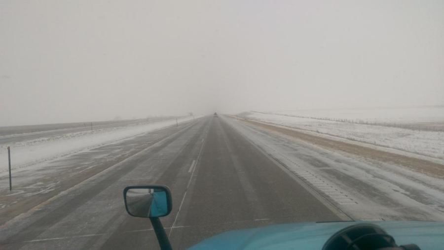 picture of snowstorm getting worse through truck drivers windshield
