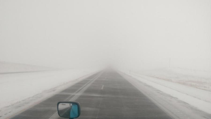 picture of snowstorm getting worse through truck drivers windshield