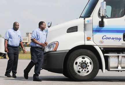two Con-way drivers in uniform by their truck