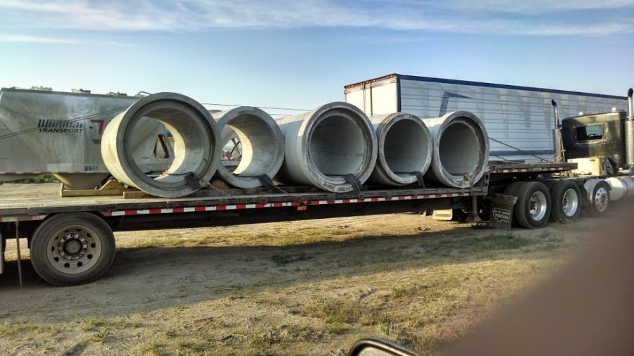 flatbed trailer loaded with big cement pipes