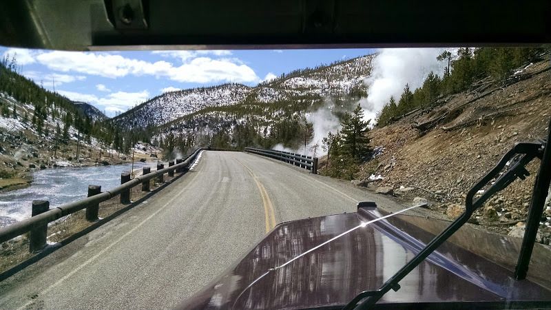 truckers view of the open road and snow covered mountains