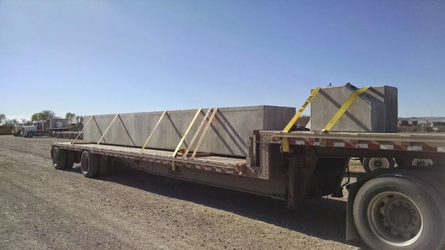 pieces of cement bridge abutment strapped on flatbed trailer