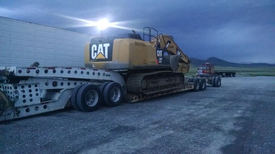 overweight Caterpillar excavator loaded on flatbed trailer