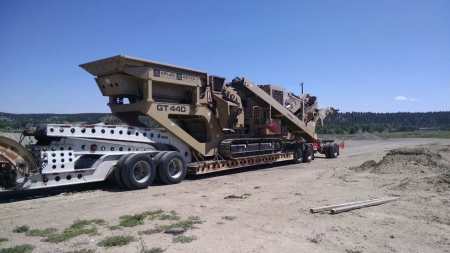 large rock crusher loaded on a flatbed trailer