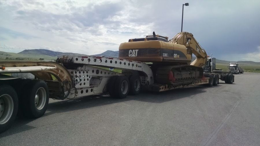flatbed trailer loaded with 330 CAT excavator that weighs about 82k