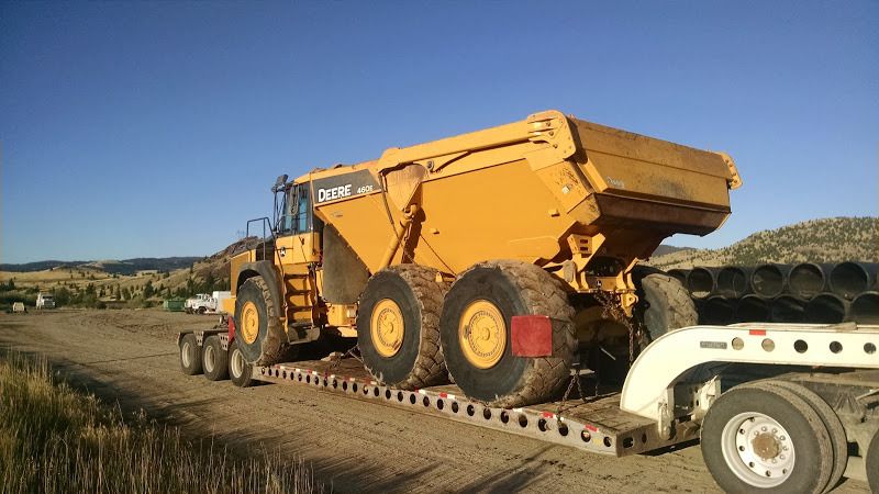 small articulating Deere dump truck loaded on flatbed trailer