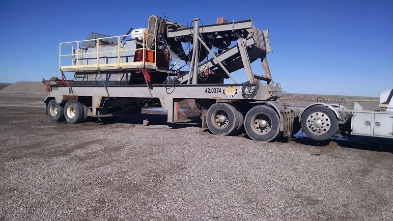 small pugmill loaded on flatbed trailer