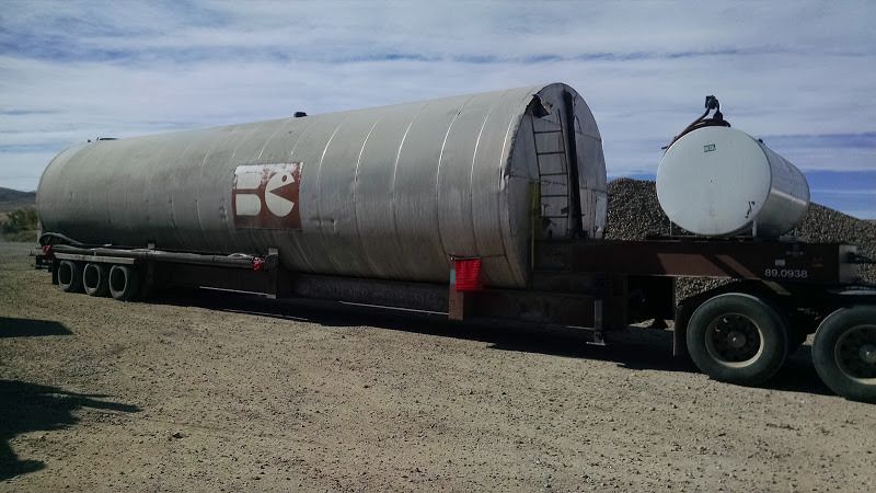 long wide steel tank loaded on a flatbed trailer