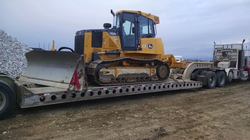 small cat excavator loaded on flatbed trailer