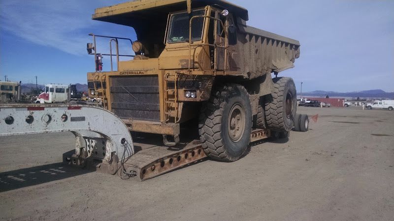 CAT 773 heavy duty dump truck loaded on a flatbed trailer