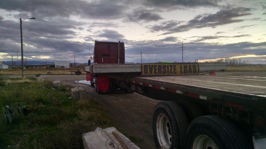 oversize wide load on a flatbed trailer in parking lot in denver