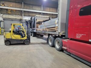 Forklift removing material from a truck.